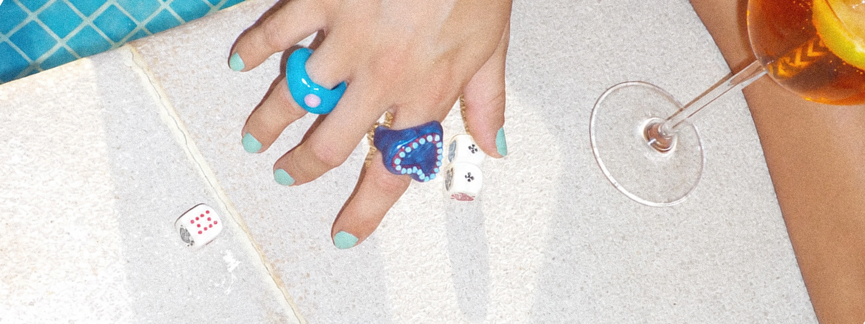FLOOPS rings beside a drink and dice